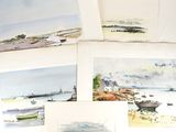 Plusieurs aquarelles représentant des bateaux sont exposées sur une surface blanche