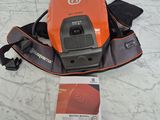 un gros plan d'un aspirateur orange et noir posé sur un sol en marbre