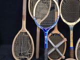 several tennis rackets are lined up against a black background