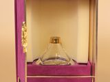 perfume bottle in a purple box with a gold handle