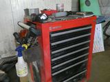 une boîte à outils rouge sur laquelle sont posés des outils, dans un garage