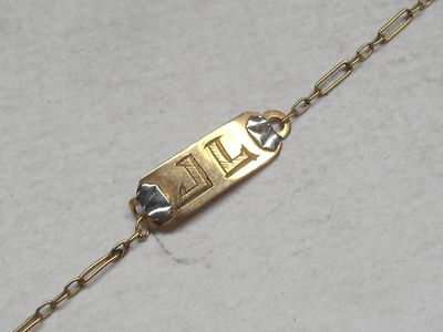 an image of a gold plated bracelet with a chain attached to it