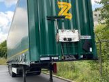 a green semi truck that is parked on the side of the road