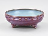 purple and blue ceramic bowl on stand on white background