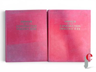 two pink books are open on a white surface with a red cover