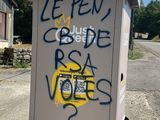 a box with graffiti on it sitting on the side of the road