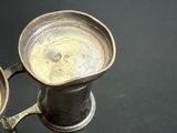 a silver cup that is sitting on a table