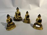 trois statues de Bouddha en or sont assises sur une surface blanche