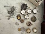 many different types of pocket watches on the table
