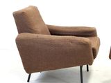 pair of mid - century lounge chairs with upholstered armrests