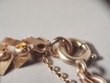 a close up of a gold chain with a flower on it
