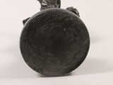 a statue of a boy sitting on top of a black object