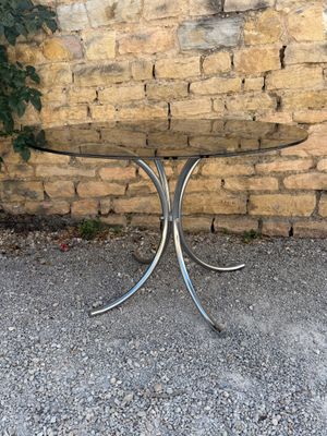 a small table with a glass top on a gravel ground