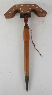 a wooden object with a wooden handle on a white surface