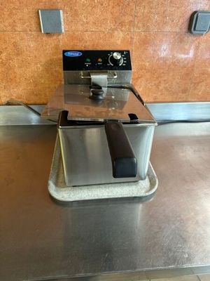 un plan de travail en acier inoxydable sur lequel est posée une friteuse professionnelle