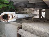 a rusted pipe sitting on the ground next to a pile of concrete blocks