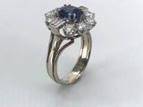 a close up of a diamond and sapphire ring on a white background