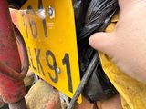 une personne tenant un sac noir au-dessus d'un tas de terre