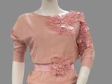 mannequin wearing a pink sweater and black pants with flowers on it