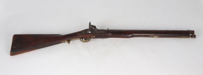 an old rifle with a wooden barrel on a white surface