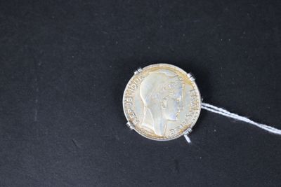 un gros plan d'une pièce de monnaie suspendue à une ficelle sur une surface noire