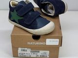 baby boy ' s blue and green star sneakers in a cardboard box