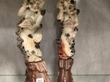 two figurines of monkeys sitting on boots on a shelf