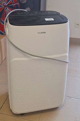 un purificateur d'air blanc et noir posé au sol