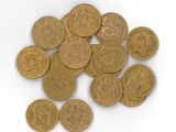 a pile of gold coins sitting on a white surface