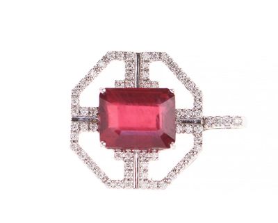 un gros plan d'une bague en pierre rouge et diamants sur fond blanc