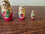 five nesting dolls sitting on a table with a white wall in the background