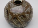 a brown and white vase sitting on a white surface