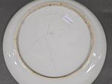 a white plate with a gold rim sitting on a table