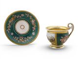 une tasse et une soucoupe vertes et dorées, avec un bord doré