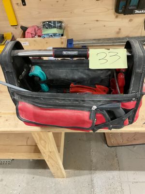 une sacoche à outils contenant des outils, posée sur un établi