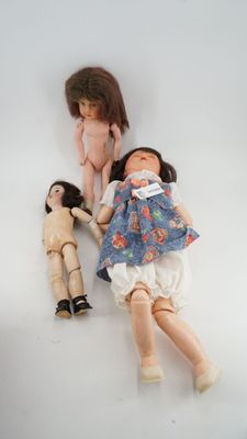 two dolls laying next to each other on a white surface