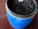 un seau bleu posé sur une palette, à côté d'une autre palette