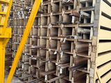 a large stack of wooden pallets in a warehouse