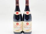 deux bouteilles de vin rouge posées l'une à côté de l'autre sur une surface blanche
