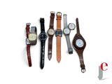 plusieurs types de montres sont alignés sur une surface blanche