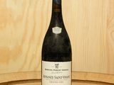 une bouteille de vin posée sur un tonneau en bois