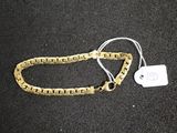 Gros plan sur un bracelet en chaîne en or portant une étiquette