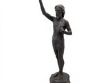 statue of a boy with a raised hand on a rock
