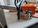 an orange and black chainsaw sitting on top of a white table