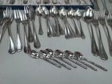 many spoons and forks laid out on the table