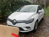 La voiture est garée sur le bord de la route, à côté d'un carton.