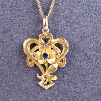 un gros plan sur un collier en or orné d'une fleur