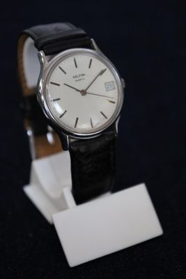 a watch that is sitting on a stand on a black surface