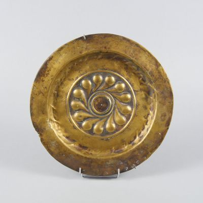 une image représentant une assiette en or ornée d'un motif floral