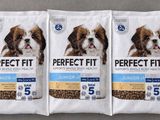 three bags of perfect fit dog food sitting on top of a table
